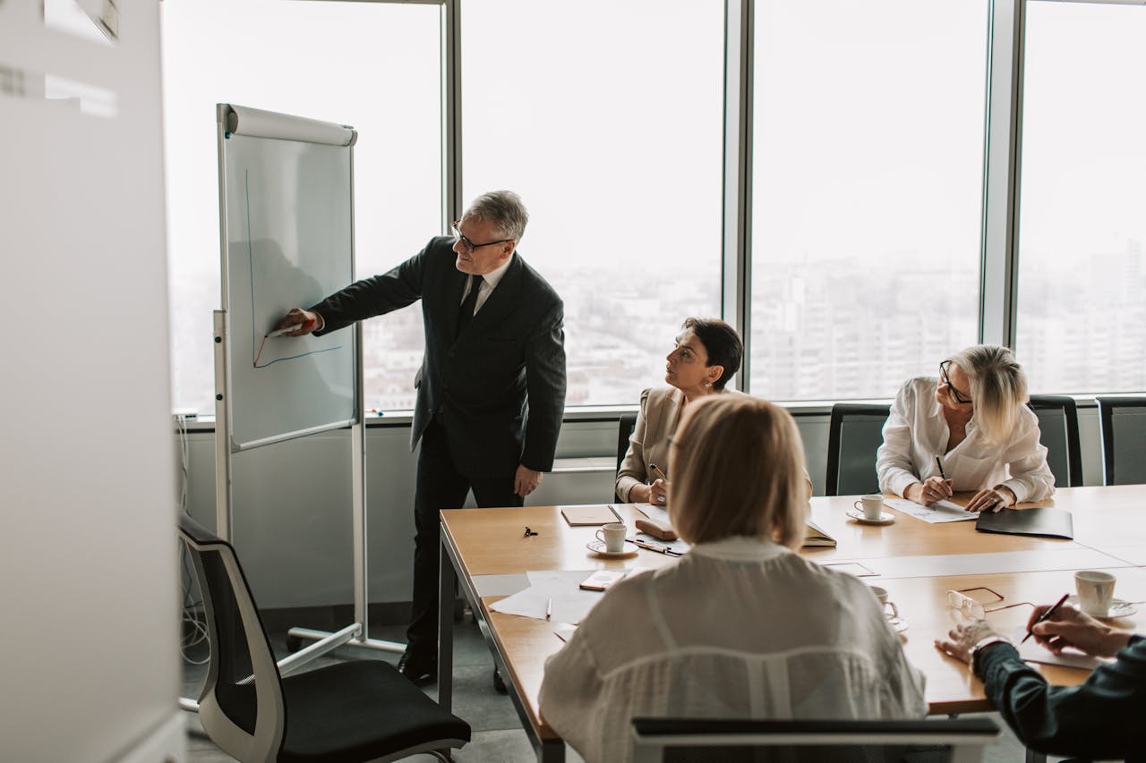 Senior executive presenting to colleagues in a modern office conference room.